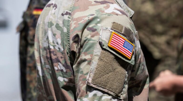U.S. soldier with U.S. flag on uniform.