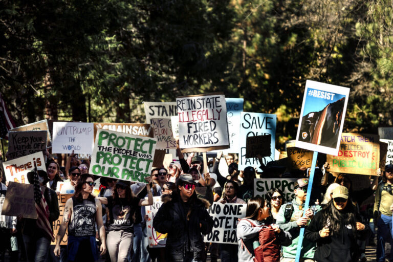 Protesters march with signs at Yosemite National Park.