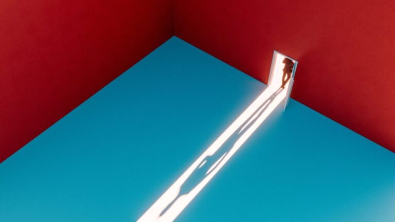 A long shadow in the door as a person exits.