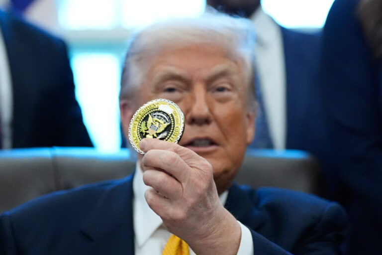 President Donald Trump holds up a presidential challenge coin